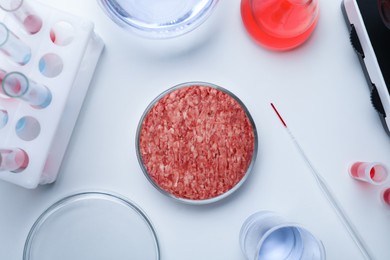 Sample of minced cultured meat on white lab table, flat lay