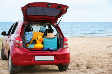 Red car with luggage on beach. Summer vacation trip