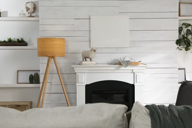 Stylish living room interior with empty canvas on white wooden wall. Mockup for design