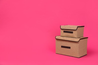 Two textile storage cases on pink background. Space for text