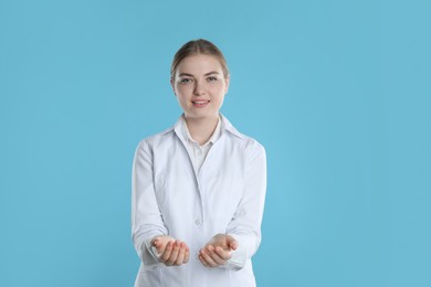 Dental assistant holding something on light blue background