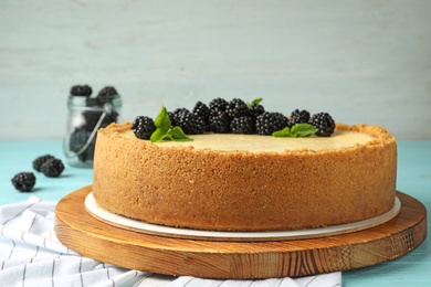 Delicious cheesecake decorated with blackberries on table