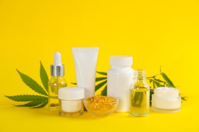 Composition with CBD oil, THC tincture and hemp leaves on yellow background