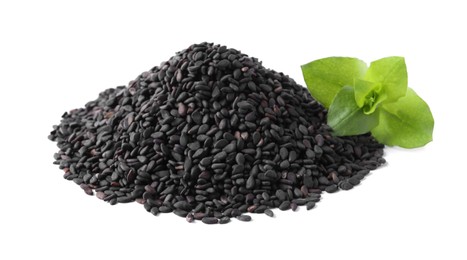 Photo of Pile of black sesame seeds with green leaf on white background