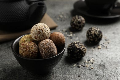 Delicious vegan candy balls on grey table, space for text