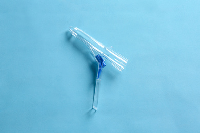 Anoscope on light blue background, top view. Hemorrhoid treatment