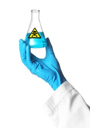 Scientist in gloves holding glass bottle with blue toxic sample and warning sign on white background