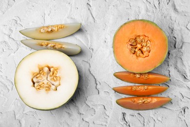 Tasty colorful ripe melons on white textured background, flat lay