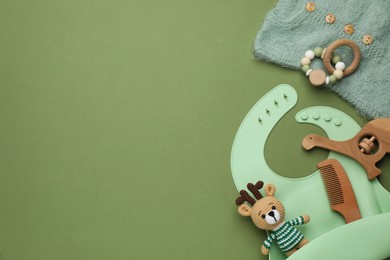 Photo of Flat lay composition with baby accessories and bib on green background, space for text
