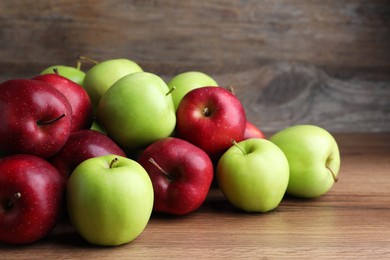 Photo of Fresh ripe red and green apples on wooden table