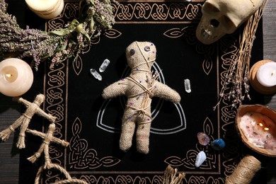 Voodoo doll pierced with pins surrounded by ceremonial items on table, flat lay. Curse ceremony