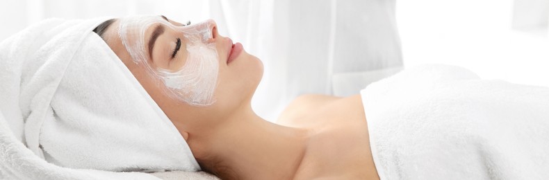 Pretty woman with mask on her face in spa salon. Banner design