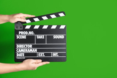 Image of Second assistant camera holding clapper board against chroma key background, closeup. Space for text