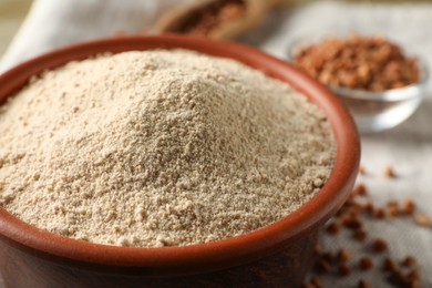Bowl of buckwheat flour on cloth, closeup