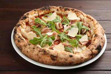 Photo of Tasty pizza with meat and arugula on wooden table, closeup