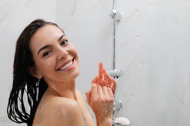 Beautiful young woman taking shower at home. Space for text