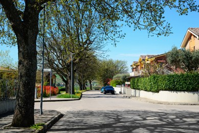 Photo of Picturesque view of beautiful suburban street on sunny spring day