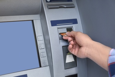 Photo of Man using cash machine for money withdrawal, closeup