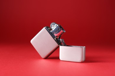 Photo of Gray metallic cigarette lighter on red background