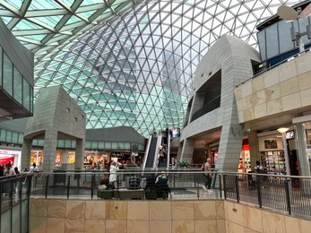 Photo of WARSAW, POLAND - JULY 17, 2022: Big shopping mall with many stores and customers