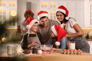 Photo of Happy family making dough for delicious Christmas cookies at home