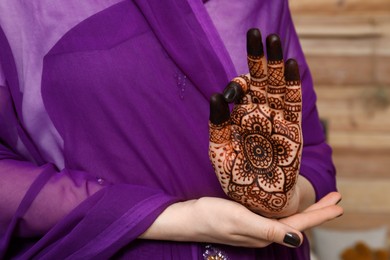 Woman with henna tattoo on palm, closeup and space for text. Traditional mehndi ornament