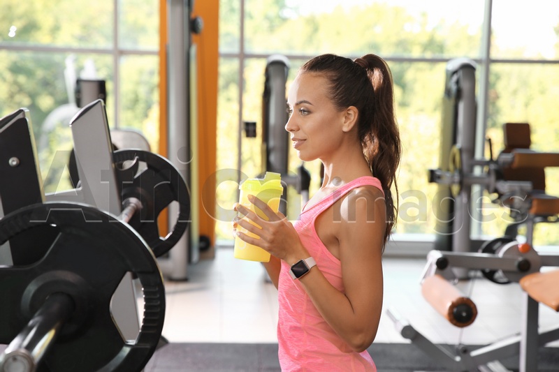 Portrait of athletic woman with protein shake in gym