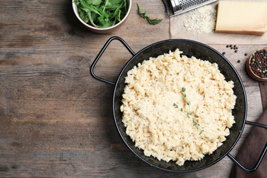 Photo of Delicious risotto with cheese on wooden table, flat lay. Space for text