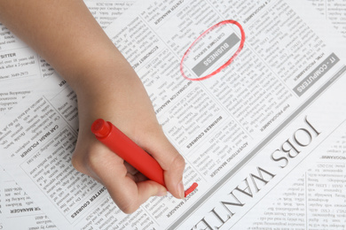 Woman marking advertisement in newspaper, closeup. Job search concept