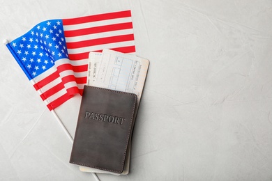 Flat lay composition with flag of USA, passport and tickets on gray background. Space for text