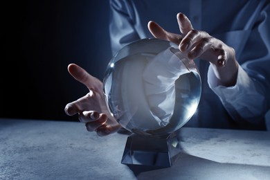 Businesswoman using crystal ball to predict future at table, closeup
