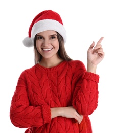 Pretty woman in Santa hat and red sweater pointing on white background