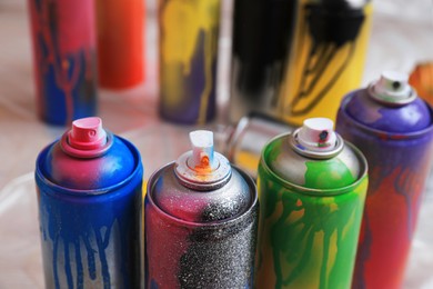 Used cans of spray paints indoors, closeup. Graffiti supplies