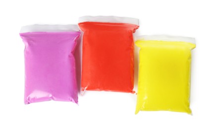Packages of colorful play dough on white background, top view