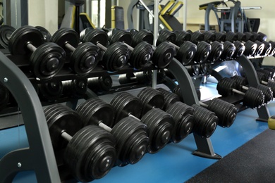 Dumbbells on rack in gym. Modern sport equipment