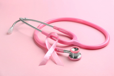 Pink ribbon and stethoscope on color background. Breast cancer concept