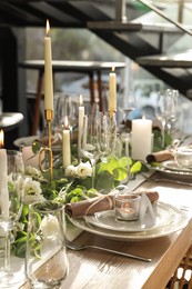 Elegant table setting with beautiful floral decor and burning candle
