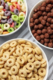 Different delicious breakfast cereals on kitchen towel, above view