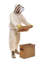 Photo of Beekeeper in uniform holding frame with honeycomb near wooden hive on white background