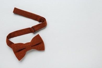 Stylish terracotta bow tie on white background, above view