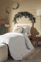 Stylish bedroom decorated with beautiful eucalyptus garland