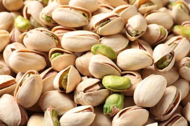 Many organic pistachio nuts as background, closeup