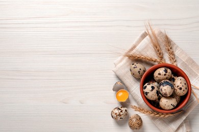 Flat lay composition with quail eggs on white wooden table. Space for text
