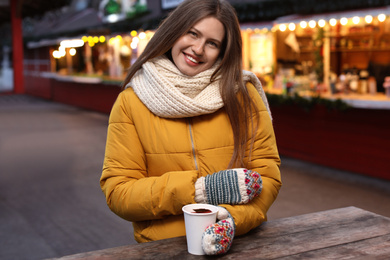 Happy woman with mulled wine at winter fair