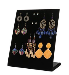 Display stand with different earrings on white background