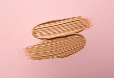 Sample of liquid skin foundation on pink background, top view