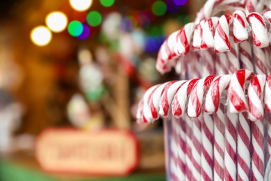 Candy canes on Christmas fair stall display, closeup. Space for text