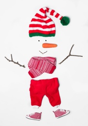 Creative snowman shape made of Santa elf's hat and different items on white background, flat lay