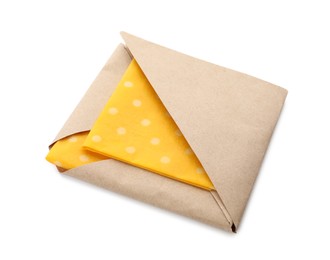 Packed yellow reusable beeswax food wraps on white background