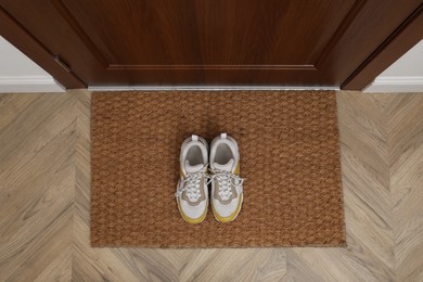 Stylish shoes on door mat in hall, top view